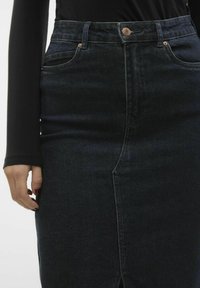 Mörk denim blyertskjol med sprund fram, hög midja och kopparfärgade knappdetaljer, med slät textur och figurnära design.