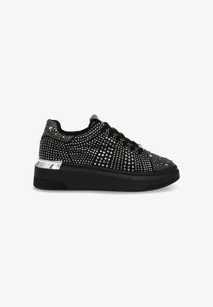 Baskets de sport noires avec des embellissements en strass, une surface texturée, un bout rond et une épaisse semelle noire avec un accent argenté.