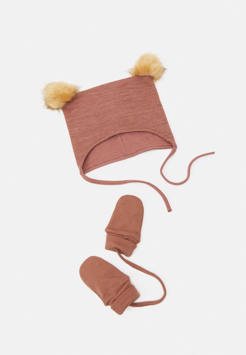 Gorro de malha castanho com pompons de pelúcia amarela no topo e luvas a condizer. O gorro apresenta laços para o queixo e tem um formato arredondado. Textura suave em todo o produto.