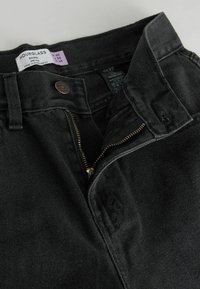 Svarta denimjeans med midjehög passform, med en mässingsdragkedja och knäppning, texturerad tyg och timformatsdesignmärke.
