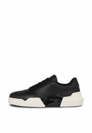 Sneaker nero basso con chiusura a lacci, suola bianca spessa e logo "Calvin Klein Jeans" sul pannello laterale.