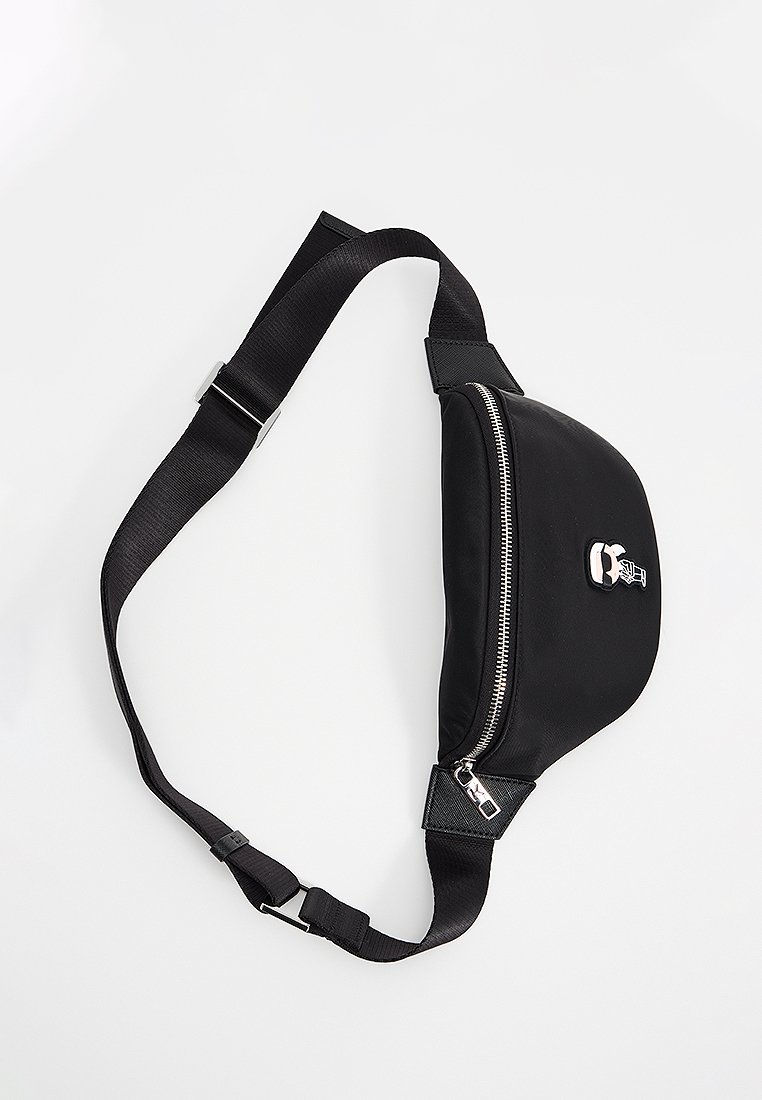 Sac banane noir en matériau lisse, doté d'une fermeture éclair à l'avant, d'une sangle réglable et d'un accent logo graphique.