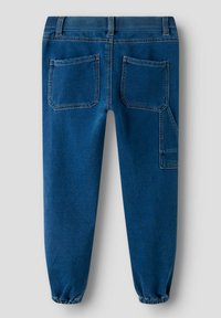 Pantalon jogger en denim bleu avec une taille élastique, deux poches arrière, des chevilles resserrées et un détail de poche latérale. Texture lisse.