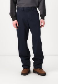 Navy blue trousers made of cotton blend fabric, featuring a straight cut, side pockets, button closure, and a smooth texture.