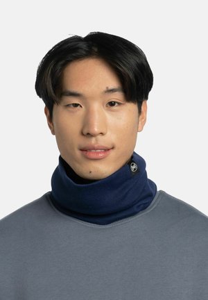 Gaiter de cuello azul hecho de material suave, presenta una textura acanalada, con una etiqueta de logo en el costado. Se lleva con un sudadera gris.