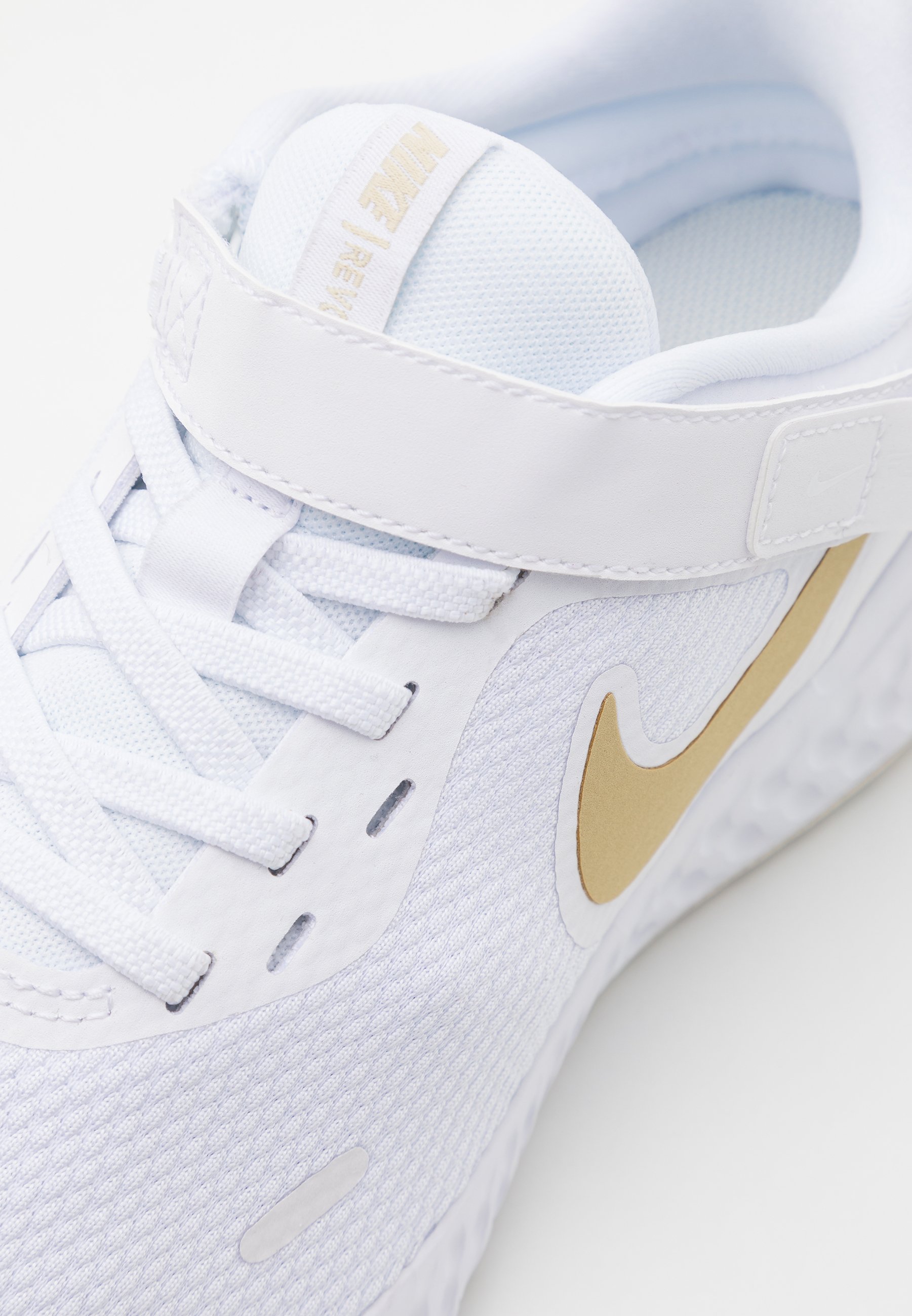 white and gold running shoes
