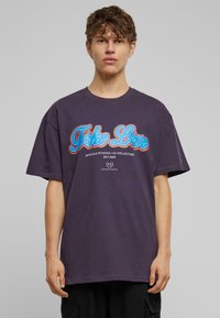 T-shirt en coton surdimensionné violet avec un graphique "Take Love" en bleu et rouge, col rond et manches courtes. Design décontracté.