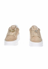 Sneaker in suede beige con suole platform bianche, caratterizzati da accenti dorati e gioielli sui lacci. Logo visibile sulla linguetta.