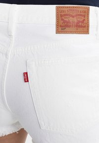 Witte denim shorts met een leren label met geperst ontwerp, een klein rood Levi's-label en een rafelige zoom.