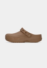 Sabots en caoutchouc marron présentant une surface texturée, une sangle latérale avec un bouton et une semelle striée, conçus pour le confort et la stabilité.