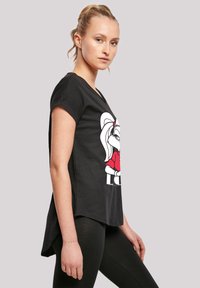 Melnā īsām piedurknēm T-kreklā ar karikatūras varoņa grafiku sarkanā un baltā krāsā, zem kuras ir teksts "MĪLESTĪBA". Mīksts audums, brīvs piegriezums.