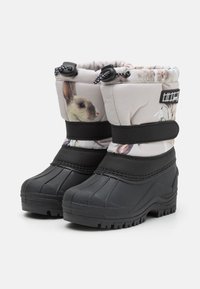 Botas infantiles aisladas con parte superior de tela rosa claro que presenta estampados de conejitos, parte inferior de goma negra, cordón ajustable y tira de Velcro.