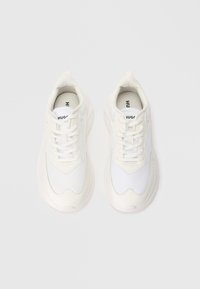 Pair of white Hugo sneakers with laces, mesh and leather details, viewed from above on a plain light background.