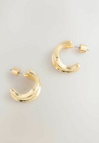 Zelta apaļas auskari ar izliekta dizaina elementu, pulētu apdari un aizdari ar tapu drošai nēsāšanai.