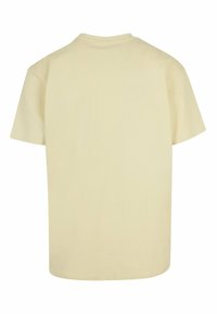 Crème t-shirt met korte mouwen, gemaakt van zachte katoen. Klassieke ronde halslijn, ontspannen pasvorm en rechte zoom zonder zichtbare patronen of grafieken.