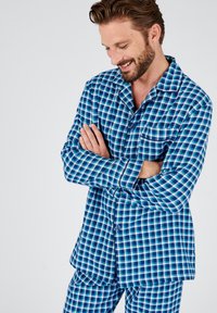 Blauwe en witte geruite pyjama set met een knoopsluiting shirt met een borstzak en bijpassende broek, gemaakt van zachte stof met een gladde textuur.