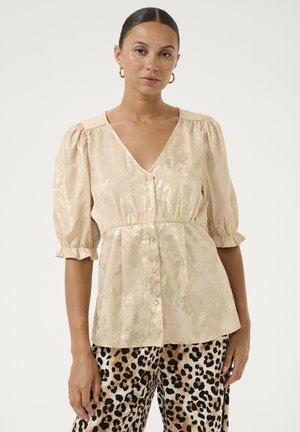 Blush-pinke Bluse mit V-Ausschnitt, puffärmeln und Knopfleiste. Besitzt einen dezenten Glanz und eine gefaltete Taille. Kombiniert mit Leopardenmuster-Hosen.