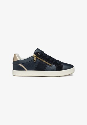 Zapatillas de cuero azul marino con detalles dorados, diseño perforado y cremallera lateral. Presenta una suela de goma blanca y tela texturizada en los laterales.