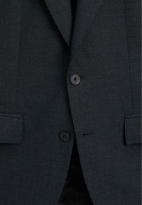 Czarny żakiet o teksturowanej fakturze, z wzorem w kratkę, zapinany na jeden guzik z dwoma czarnymi guzikami i eleganckim kołnierzem.