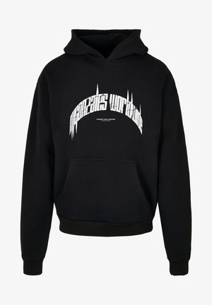 Svart hettegenser med frontlomme. Har hvit tekstgrafikk på brystet. Tøyet har en jevn, varm tekstur.