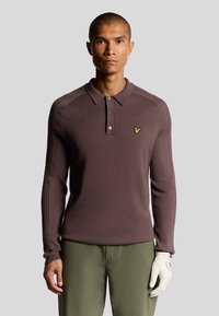 Polo a maniche lunghe in tessuto mauve scuro, caratterizzato da una chiusura a tre bottoni, colletto a costine e un'emblema dorato sul petto. Maniche texturizzate con righe.