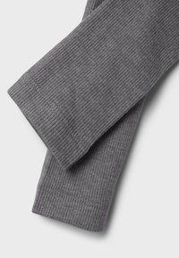 Grå ribbestrikkede leggings med en myk tekstur, som har en tettsittende passform og pent sydd søm, lagt flatt for å vise detaljer.