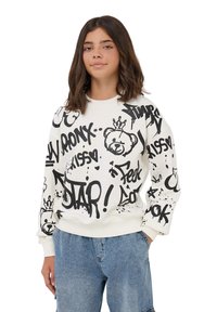 Biała bluza z czarnym tekstem w stylu graffiti i grafiką niedźwiedzia, z prążkowanymi mankietami i okrągłym dekoltem. Połączona z niebieskimi szortami dżinsowymi.