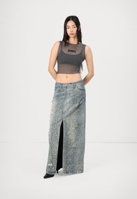 Pilkas permatomas trumpas viršus su užrašu "Ragged", derinamas su mėlyna gyvatės rašto džinsine sijoną su šoniniu plyšiu ir suplėšytais akcentais.