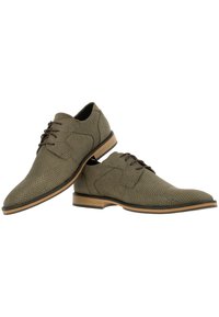 Olijfgroene dresschoenen met een textuurpatroon, vetersluiting en een contrasterende tan zool. Kenmerkend zijn de ronde neus en minimale stiksels.