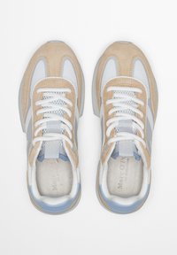 Μπεζ πάνινα παπούτσια από σουέντ και λευκό δίχτυ με γκρι λεπτομέρειες, στρογγυλές μυτερές άκρες και λευκά κορδόνια. Λαστιχένια σόλα με μπλε λεπτομέρειες κοντά στη φτέρνα.