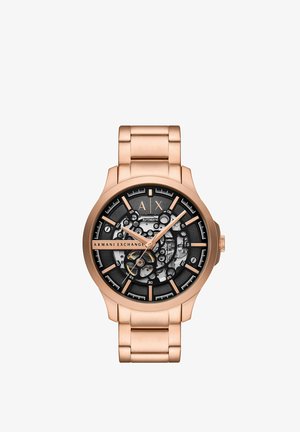 Reloj automático con brazalete de acero inoxidable en oro rosa, carátula negra y mecanismos interiores transparentes. Las marcas incluyen indicadores de horas y minutos.