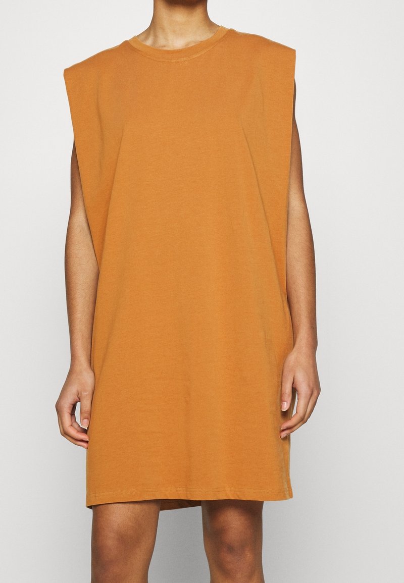 Ylihäntä ilmanhiha dressi lämpimässä oranssissa sävyssä, valmistettu pehmeästä puuvillasta, suoralla leikkauksella ja hillityllä kaula-aukolla, joka omaa sileän pinnan.