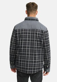 Koszula flanelowa w czarno-szary wzór w kratę z jasnoszarym yoke. Długie rękawy z guzikami na mankietach. Miękka tekstura.