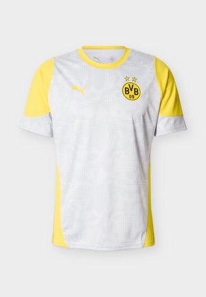 Fehér sportmez sárga díszítésekkel és rövid ujjakkal, texturált mintával, Puma logóval és Borussia Dortmund címkével.