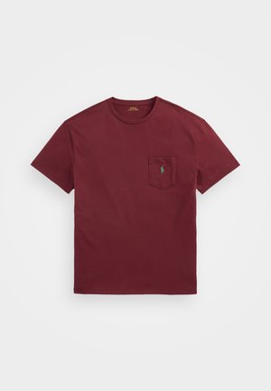 Burgunderfarget bomulls T-skjorte med rund hals, korte ermer og en frontlomme med en grønn brodert logo. Glatt tekstur.