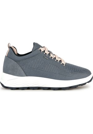 Baskets de sport grises avec des panneaux en maille et en suede, un design texturé, des lacets plats, et une semelle intermédiaire blanche avec une semelle extérieure noire adhérente.