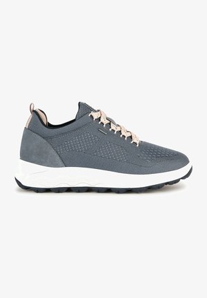 Zapatilla deportiva gris con paneles de malla y ante, diseño texturizado, cordones planos y una entresuela blanca con una suela exterior negra antideslizante.