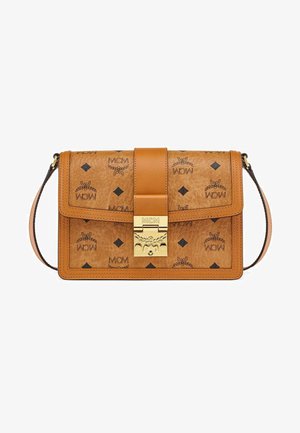 Sac en cuir tan présentant des logos MCM embossés et des motifs en losanges noirs, avec un fermoir en or et une bandoulière amovible.