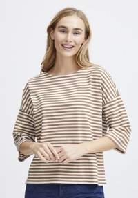 T-shirt di cotone a righe con righe orizzontali marroni e crema, scollatura a barca ampia e maniche 3/4. Vestibilità casual, texture morbida.