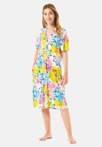 Camisa de noche de manga corta con estampado floral en colores brillantes que incluyen amarillo, rosa y azul. De longitud hasta la rodilla, con un cierre de botones en la parte delantera y bolsillos laterales.