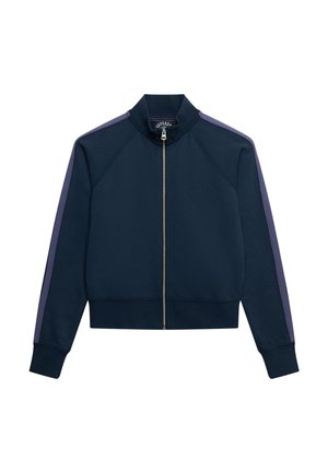 Veste zippée bleu marine en tissu doux avec un col montant, dotée de panneaux latéraux violets et d'un logo subtil embossé sur la poitrine.