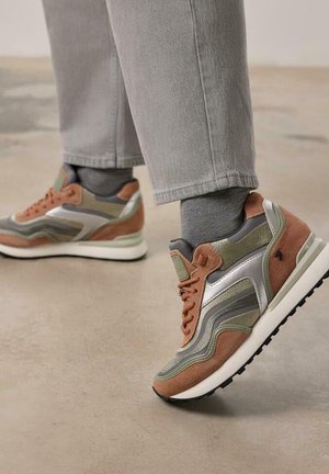 Baskets multicolores avec une tige en daim marron et gris, des accents argentés et une semelle en caoutchouc blanc. Comprend des panneaux texturés et des lacets.
