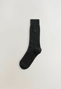 Schwarze Socke aus glattem Material mit einem gerippten Bund. Verfügt über ein dezentes Logo an der Seite. Klassisches Design, knöchellang.