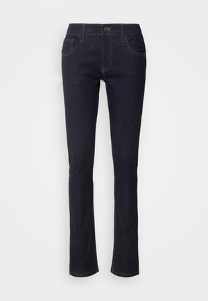 Mørkeblå denimjeans med lige ben, der har forlommer, knaplukning og subtile stikninger. Klassisk design.