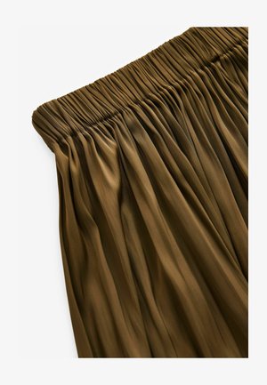 Elastický pás sukne s plisovaním v tmavo olivovej farbe. Textúra je hladká s vertikálnymi záhybmi, ktoré vytvárajú prúdny dizajn.