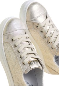 Sneaker di colore chiaro con punta metallica argentata, pannelli laterali beige testurizzati, lacci in tessuto e suola in gomma bianca.