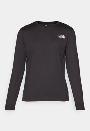 Langermet svart t-skjorte laget av myk bomull, med rund hals og en liten hvit logo på øvre venstre side. Jevn tekstur.