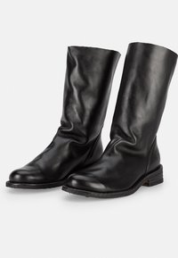 Bottines noires en cuir avec une texture lisse, un bout arrondi et un petit talon empilé. Le design présente un dessus flaccide et des coutures discrètes.