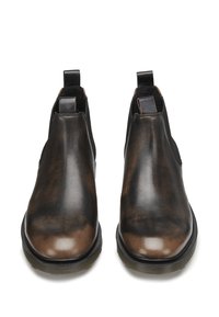 Brązowe skórzane botki za kostkę z elastycznymi panelami bocznymi, zaokrąglonym noskiem i teksturowanym wykończeniem. Czarna gumowa podeszwa z subtelnym wzorem bieżnika.