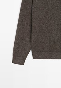 Langärmeliger, gerippter Strickpullover in Dunkelbraun mit eng anliegenden Bündchen und Bund, flach auf weißem Hintergrund dargestellt.